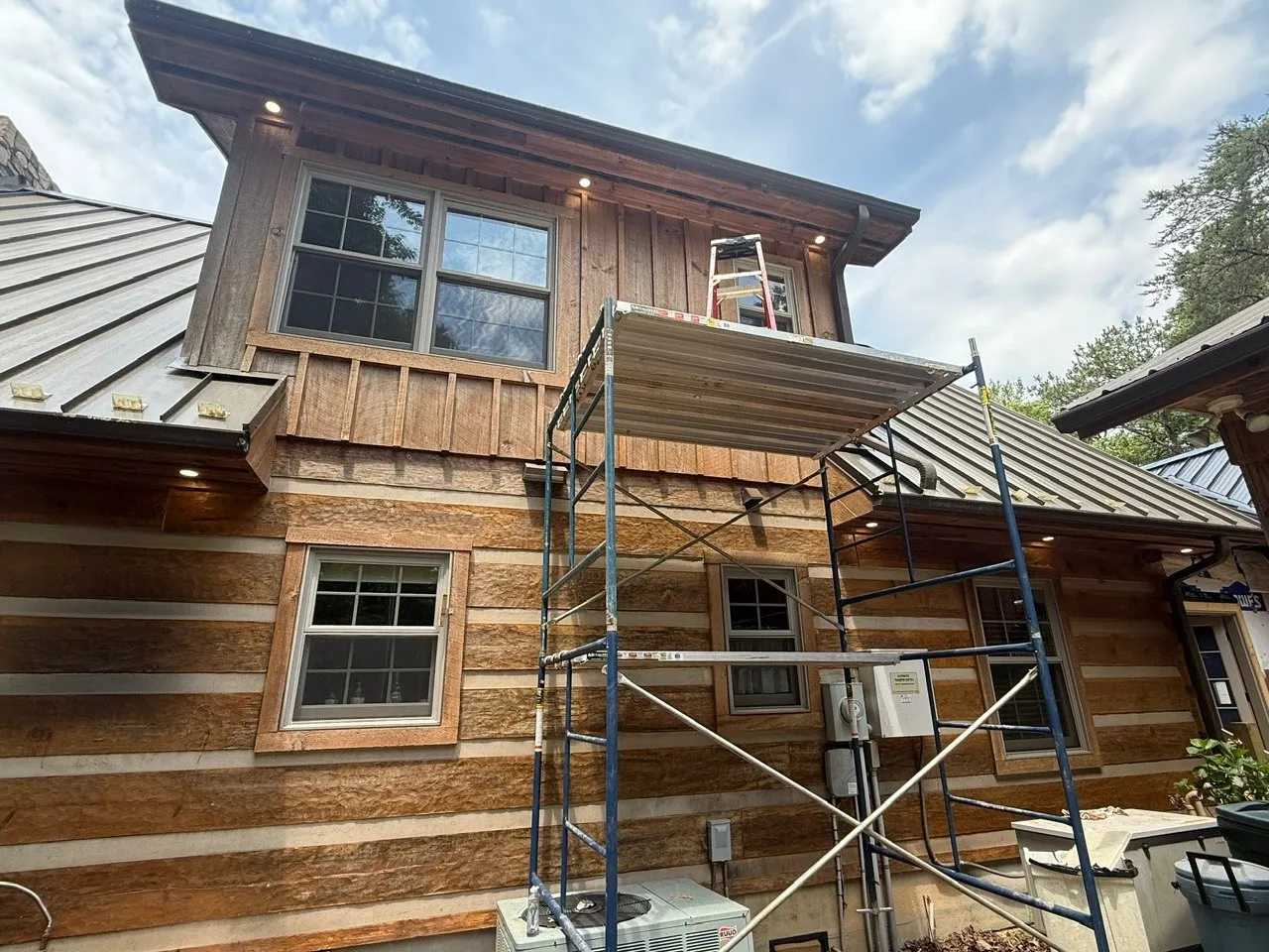 Log home exterior with soffit lights and a new service on the wall