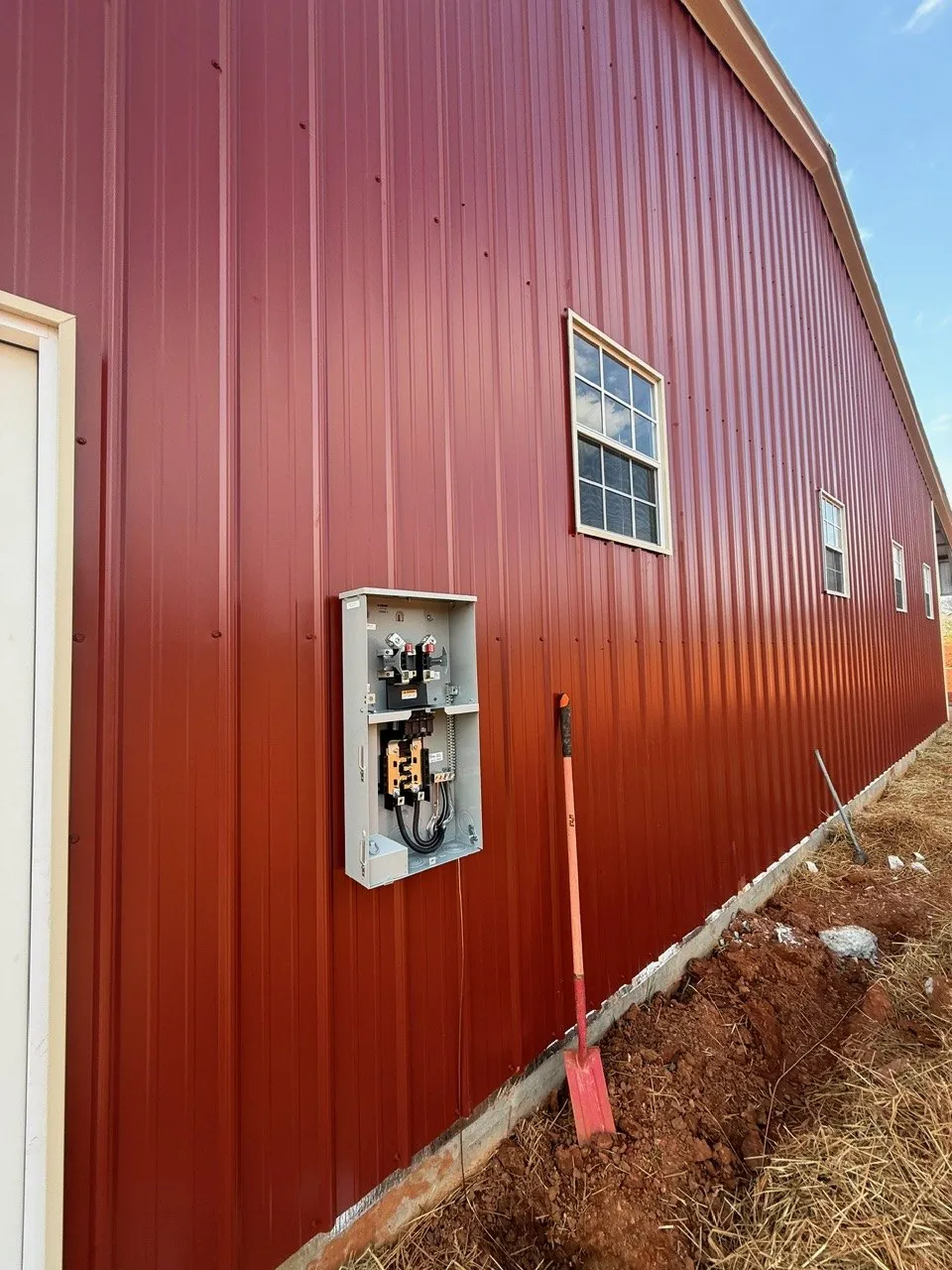 New meter base on the side of a red metal building